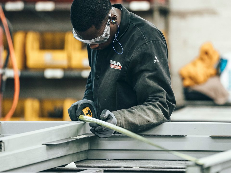 Man measuring metal and reading measuring tape